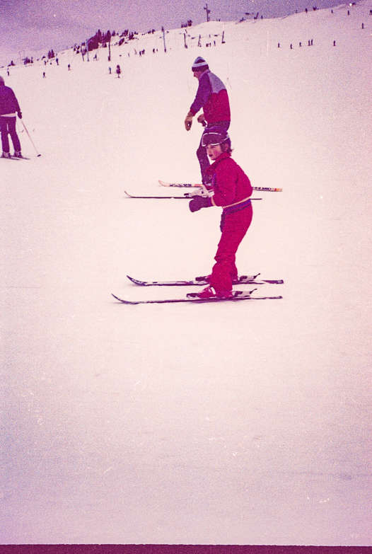 Young Ralph practising skiing in a red ski suit