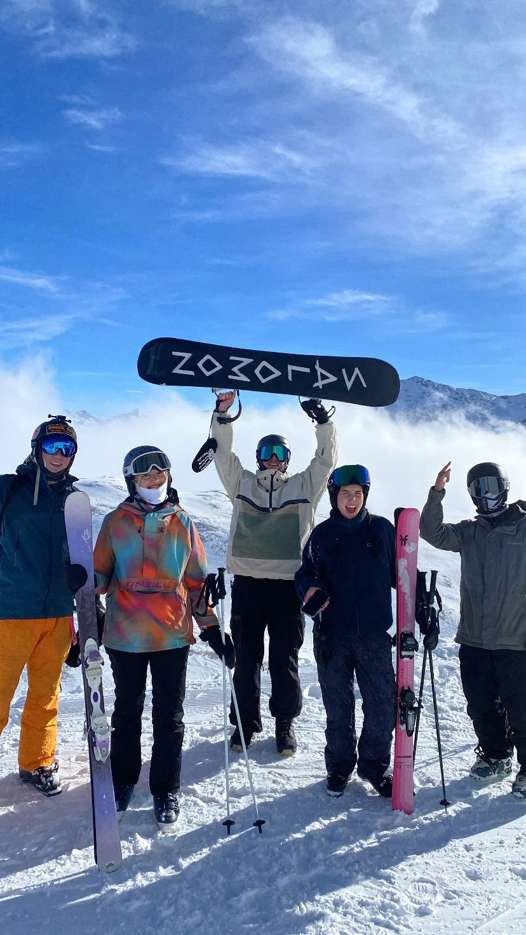 Five friends with skis and a snowboard at the top of the Perce-Neige funicular in the Grande Motte sector, Tignes.