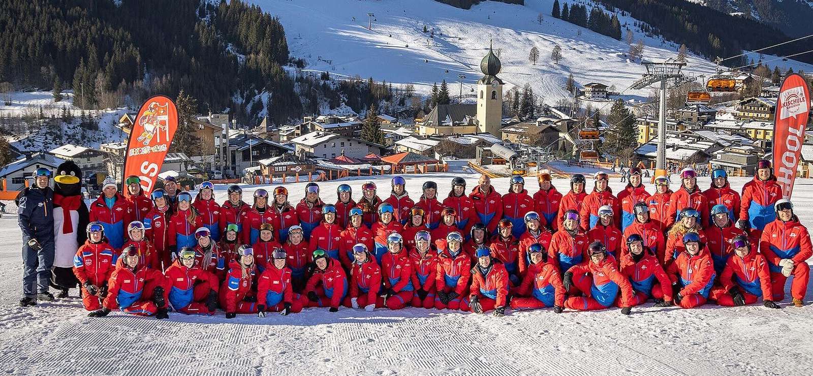 Fürstauer ski instructors in red uniforms on the snow in Saalbach